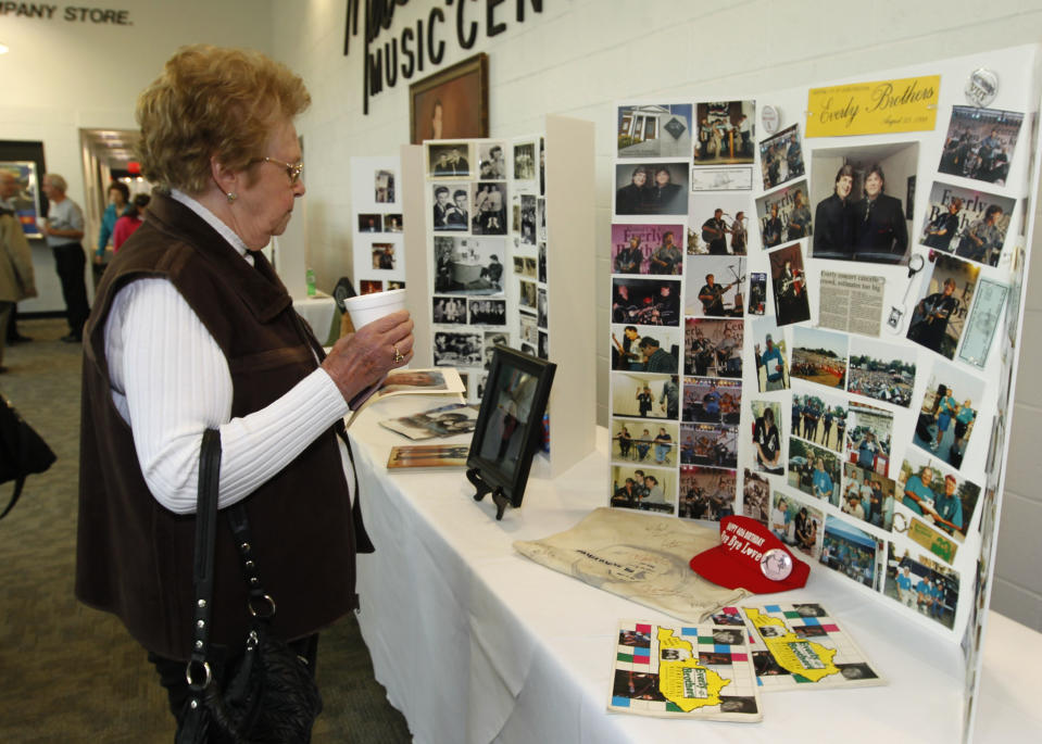 Everly Brothers fan Ura Mae Jarvis, of Central City, Ky, look over memorabilia and photo's of The Everly Brothers before a memorial service for Phil Everly at the Merle Travis Music Center in Powderly, Kentucky, Saturday, Jan. 18, 2014. (AP Photo/John Sommers II)