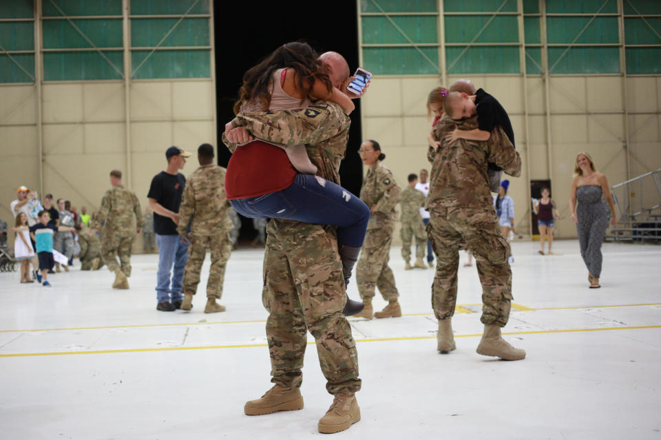 Members of the U.S. Army's 159th Combat Aviation Brigade, 101st Airborne Division, embrace family members following a homecoming ceremony at Campbell Army Airfield on Sept. 1, 2014, in Fort Campbell, Kentucky.