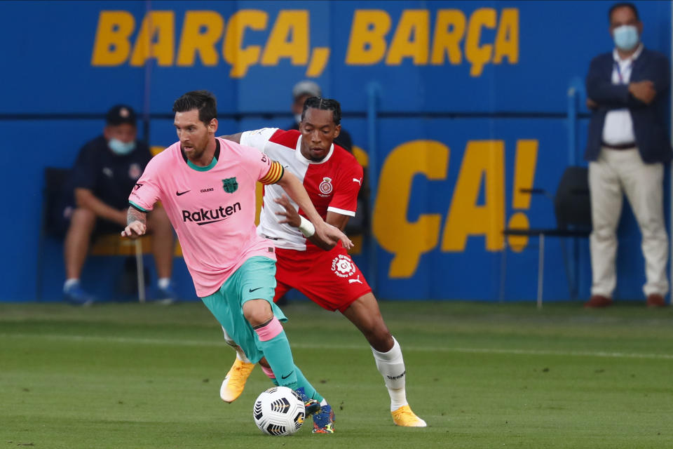 El delantero argentino Lionel Messi del Barcelona avanza con el balón frente al colombiano Johan Mojica del Girona en un partido amistoso en el estadio Johan Cruyff de Barcelona, España, el miércoles 16 de septiembre de 2020. (AP Foto/Joan Monfort)