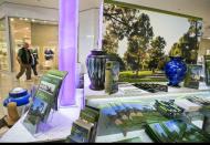 In this photo taken Thursday, Jan. 30, 2014, Mark Sanchez and his wife Lea' Anne Sanchez look at a Dodger's theme cremation urn at the Forest Lawn stand at the Glendale Galleria mall in Glendale, Calif. Forest Lawn, famous as the final resting place for everyone from Al Jolson to Michael Jackson, has begun staffing outlets at shopping malls, reasoning that planning for death, either for a loved one or yourself, might not be quite as intimidating for some people if it takes place in a lively, happy place like a mall rather than the more somber confines of a cremation home. (AP Photo/Damian Dovarganes)