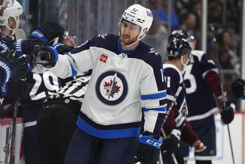 Winnipeg Jets center Gabriel Vilardi is congratulated as he passes the team box after scoring a goal in the first period of an NHL hockey game against the Colorado Avalanche, Saturday, April 13, 2024, in Denver. (AP Photo/David Zalubowski)