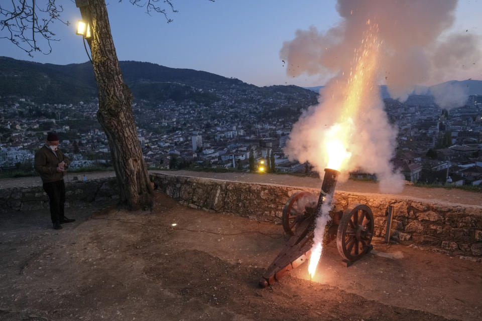 Un hombre dispara un cañón antiguo para señalar el fin del ayuno del día en Sarajevo, Bosnia, 24 de abril de 2020, en el mes sagrado del Ramadán, (AP Foto/Kemal Softic)