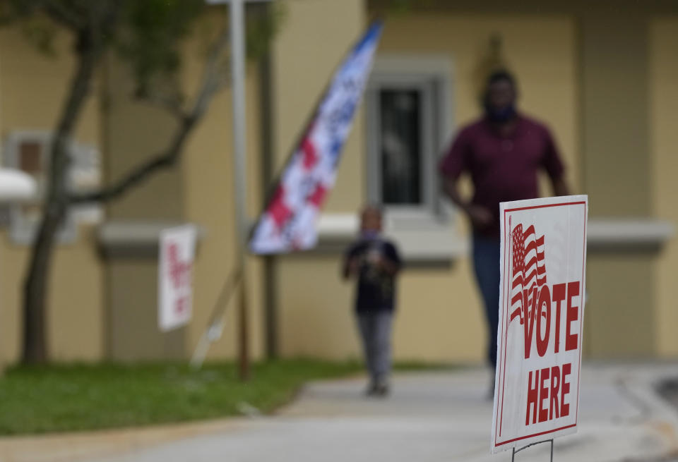 A man, who said he voted early, picks up his son from the Sunset Lakes Community Center, where voting was taking place in a special election for Florida's 20th Congressional District seat, Tuesday, Jan. 11, 2022, in Miramar, Fla. Democrat Sheila Cherfilus-McCormick, a health care company CEO, faces Republican Jason Mariner in the special election to fill the US congressional seat left vacant after Democratic U.S. Rep. Alcee Hastings died last April of pancreatic cancer. (AP Photo/Rebecca Blackwell)