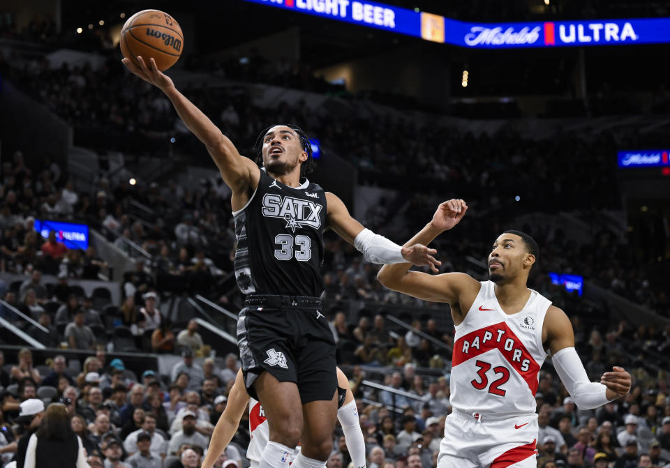 San Antonio Spurs' Tre Jones (33) goes to the basket against Toronto Raptors' Otto Porter Jr. (32) during the first half of an NBA basketball game, Sunday, Nov. 5, 2023, in San Antonio. (AP Photo/Darren Abate)