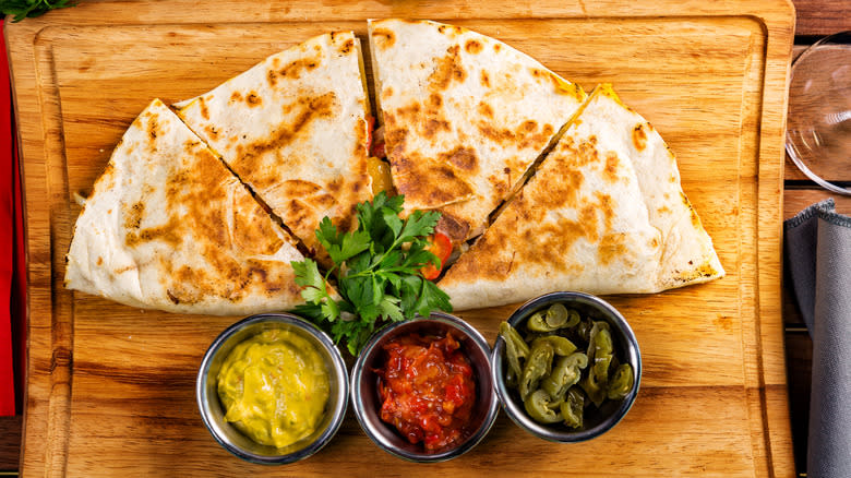 Sliced quesadilla on wooden board