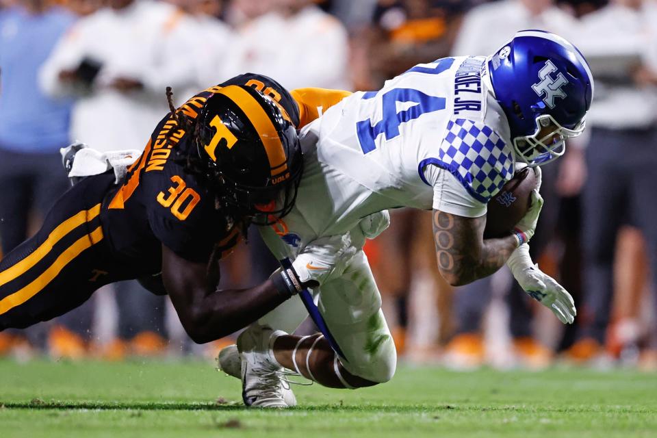 Kentucky running back Chris Rodriguez Jr. (24) dives for yardage as he is tackled by Tennessee defensive lineman Roman Harrison (30) during the first half of an NCAA college football game Saturday, Oct. 29, 2022, in Knoxville, Tenn. (AP Photo/Wade Payne)