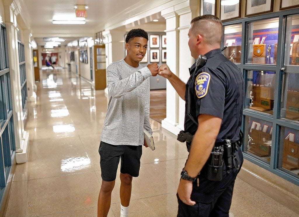 Worthington police officer Sean Ord greets Noah Tennant, then a senior at Thomas Worthington High School, in this file photo from Aug. 16, 2018. Worthington City Schools' school resource officer (SRO) program was discontinued after two years by the school board in 2020. Last year, a student started a petition drive to bring back the SROs, but the state and federal money Ohio is allocating for safety and security at schools is one-time money and thus not for permanent employment of SROs.