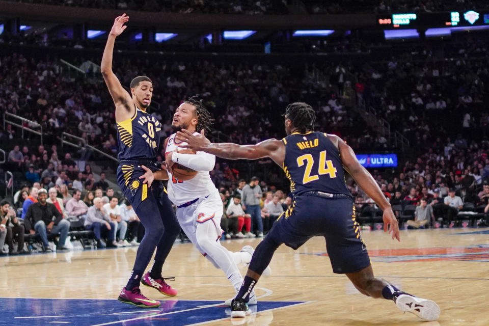 New York Knicks guard Jalen Brunson (11) fights for the ball against Indiana Pacers guards Buddy Hield (24) and Tyrese Haliburton (0) during the second half of a preseason NBA basketball game Friday, Oct. 7, 2022, in New York. (AP Photo/Eduardo Munoz Alvarez)