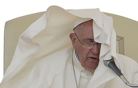 A gust of wind blows the mantle of Pope Francis as he leads his Wednesday general audience in Saint Peter's square at the Vatican June 17, 2015. REUTERS/Max Rossi -