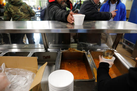 Fish soup is served for lunch to homeless men sheltering in the Pine Street Inn in Boston, Massachusetts, U.S., January 5, 2018. The Pine Street Inn, which normally requires everyone to leave during the day, is offering shelter day and night because of prolonged cold weather gripping the northeastern United States. REUTERS/Brian Snyder