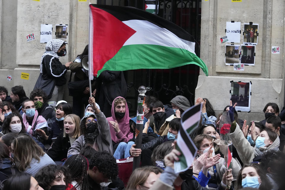 A student wave a palestinian flag outside Sciences-Po university in Paris Friday, April 26, 2024. Students in Paris inspired by Gaza solidarity encampments at campuses in the United States blocked access to a campus building at a prestigious French university Friday, prompting administrators to move all classes online. The pro-Palestinian protest at the Paris Institute of Political Studies, known as Sciences Po, came two days after police broke up a separate demonstration at one of the university's amphitheaters. (AP Photo/Michel Euler)