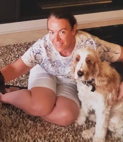 Melissa Caddick pictured sitting on a rug with a dog.