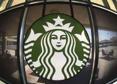 The Starbucks logo hangs on a window inside a newly designed Starbucks coffee shop in Fountain Valley, California August 22, 2013. REUTERS/Mike Blake