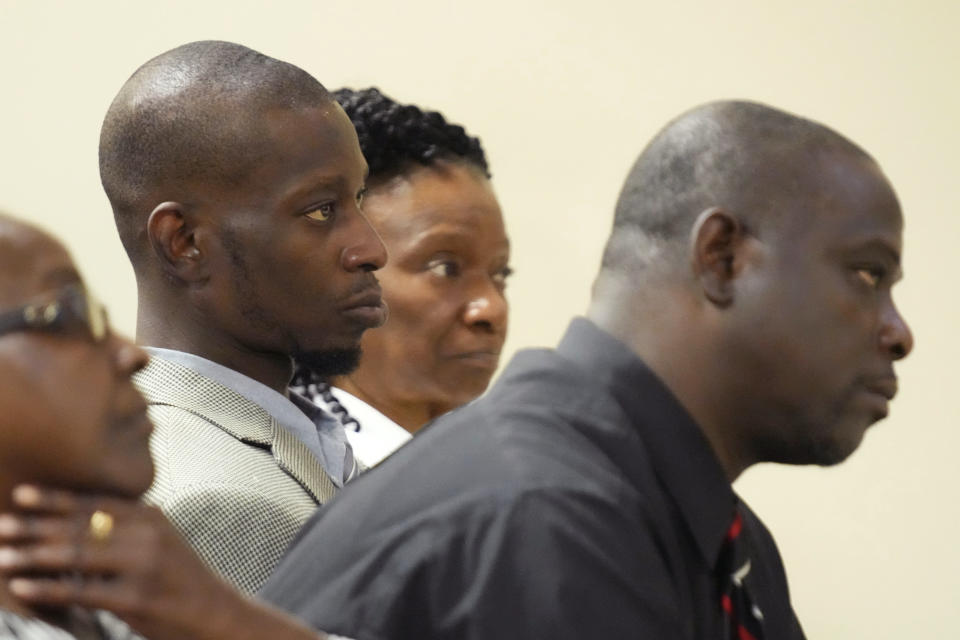 FILE - Michael Corey Jenkins, center, and Eddie Terrell Parker, right, listen as one of six former Mississippi law officers pleads guilty to state charges at the Rankin County Circuit Court in Brandon, Miss., Aug. 14, 2023. The two Black men who were tortured by six former Mississippi law enforcement officers in a violent episode last year called Monday, March 18, 2024 for a federal judge to impose strict penalties at sentencing hearings set to occur this week. (AP Photo/Rogelio V. Solis, file)