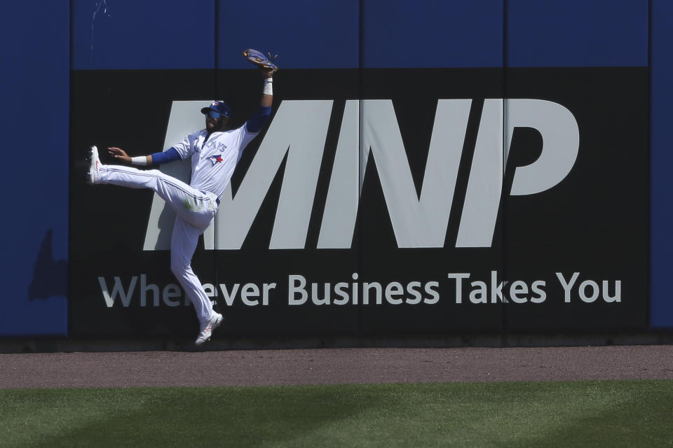 Toronto Blue Jays left fielder Lourdes Gurriel Jr. (13) makes a leaping catch to get out Houston Astros' Alex Bregman during the sixth inning of a baseball game in Buffalo, N.Y., Sunday, June 6, 2021. (AP Photo/Joshua Bessex)