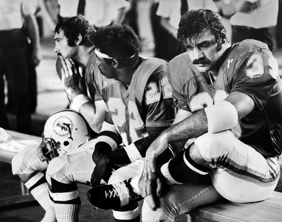 Dolphins running backs Jim Kiick, left, Mercury Morris and Larry Csonka take a break during a game.