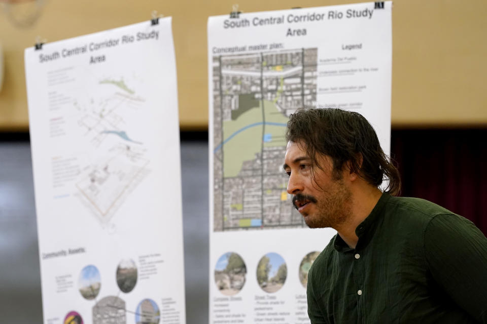 FILE - Environmental activist Reggie Carrillo speaks with community members, Friday, Sept 28, 2022, in Phoenix. Carrillo has benefited from one of several nonprofit initiatives to educate and engage residents about climate fueled heat that disproportionately affects low income neighborhoods of color. As heat waves fueled by climate change arrive earlier, grow more intense and last longer, people over 60 who are more vulnerable to high temperatures are increasingly at risk of dying from heat-related causes. (AP Photo/Matt York,File)