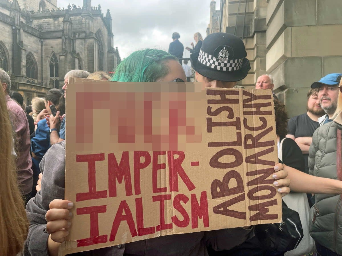 A protester before the Accession Proclamation Ceremony at  Mercat Cross, Edinburgh, publicly proclaiming King Charles III as the new monarch on 11 September 2022 (PA)