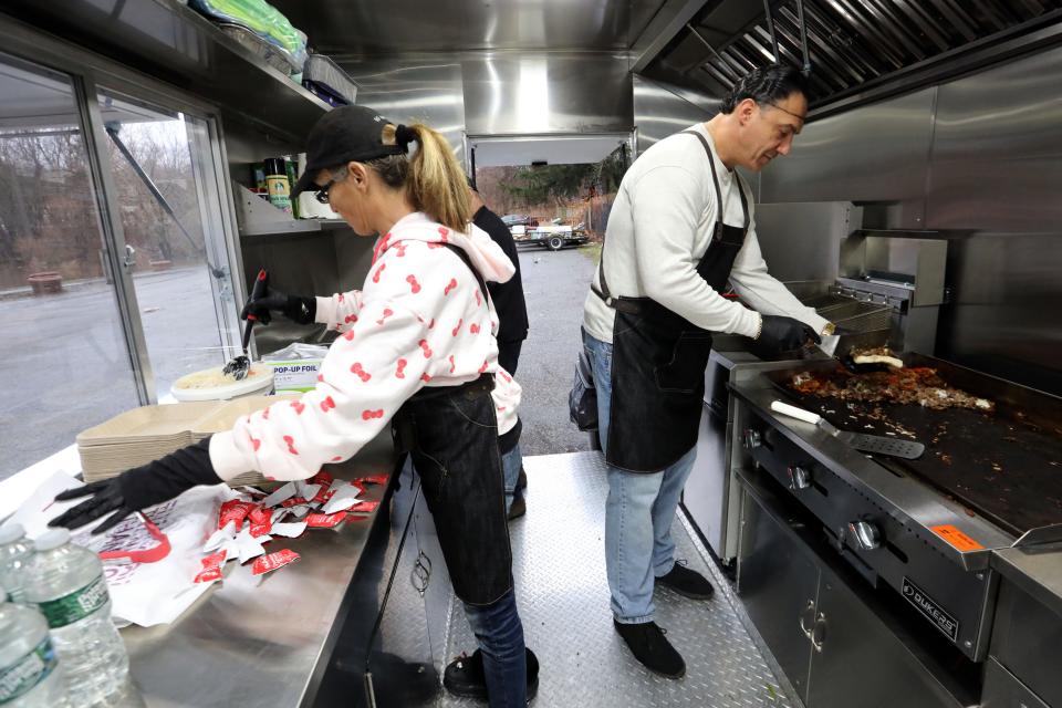 Executive Director Anna Kobelka, left, and Michelangelo Giordano, a volunteer and board member, prepare meals on the new Helping Hands For the Homeless of Rockland food truck, while parked in Memorial Park in Spring Valley Dec. 28, 2023.