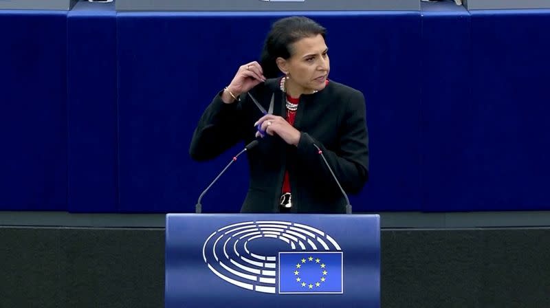 Swedish lawmaker Abir Al-Sahlani cuts her hair as she delivers a speech at EU Parliament in Strasbourg