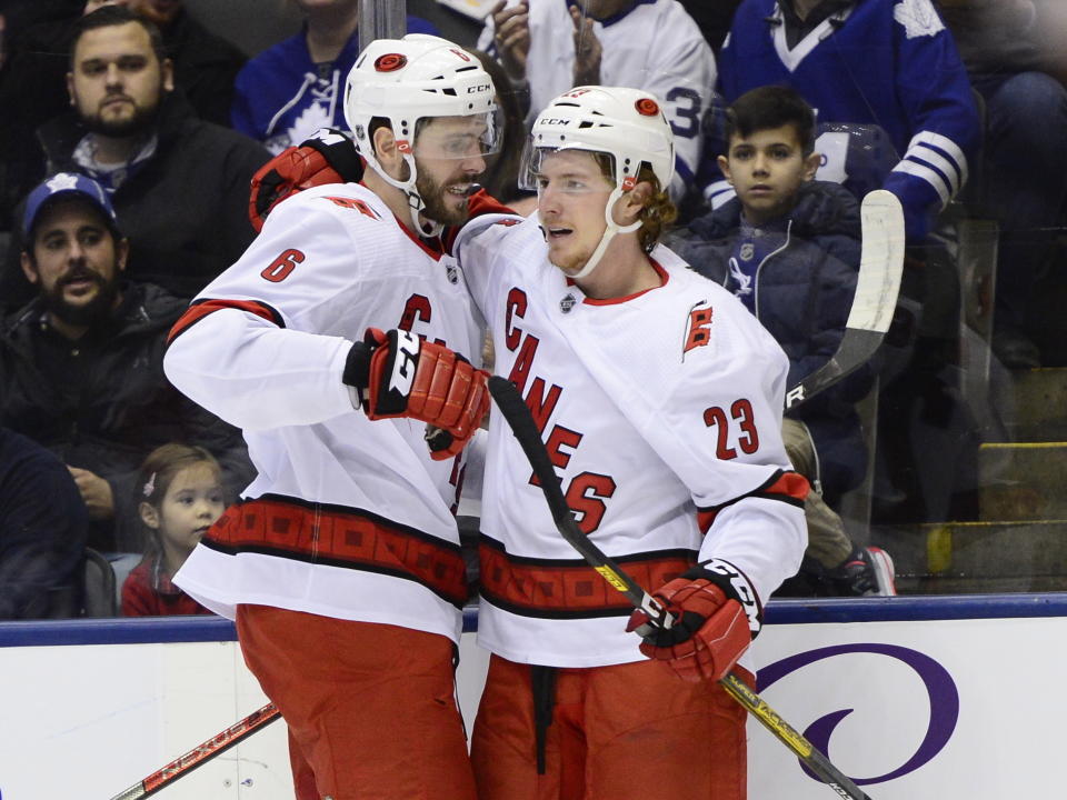 Carolina Hurricanes left wing Brock McGinn (23) celebrates his shorthanded goal with teammate Joel Edmundson (6)during first period NHL hockey action in Toronto, Monday, Dec. 23, 2019. (Frank Gunn/The Canadian Press via AP)