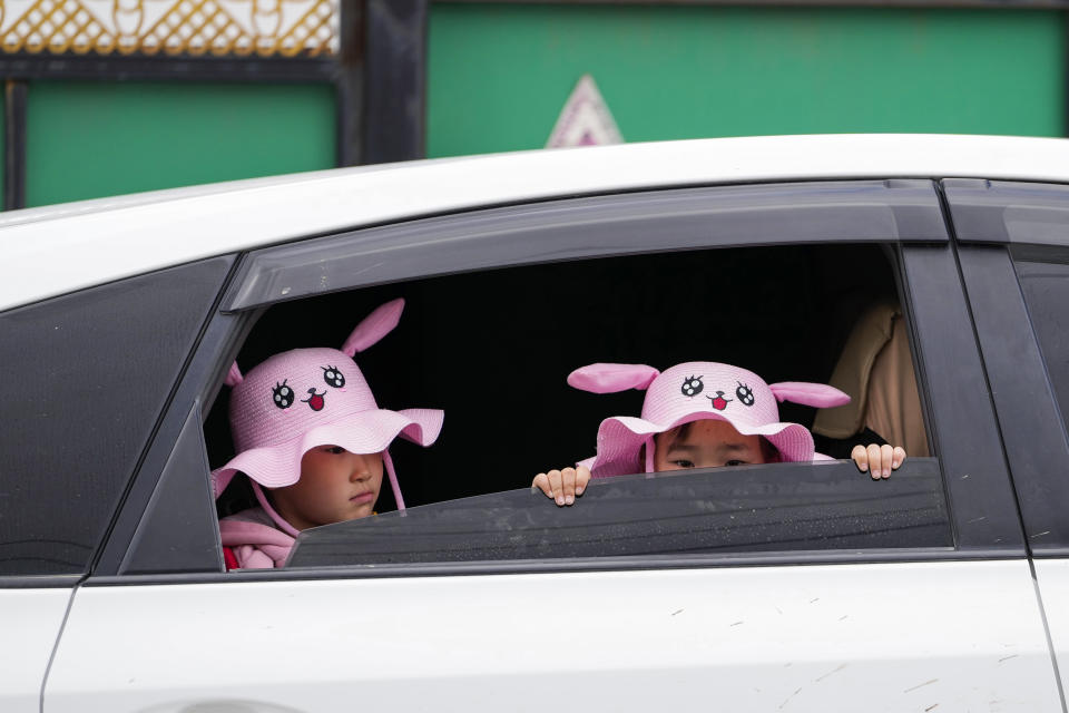 Children wait in a car outside a polling station in a Ger district on the outskirts of Ulaanbaatar, Mongolia, Friday, June 28, 2024. (AP Photo/Ng Han Guan)