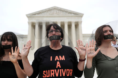 Women stand in silent protest outside the U.S. Supreme Court building after the U.S. Senate voted to confirm the Supreme Court nomination of Judge Brett Kavanaugh on Capitol Hill in Washington, U.S., October 6, 2018. REUTERS/Jonathan Ernst