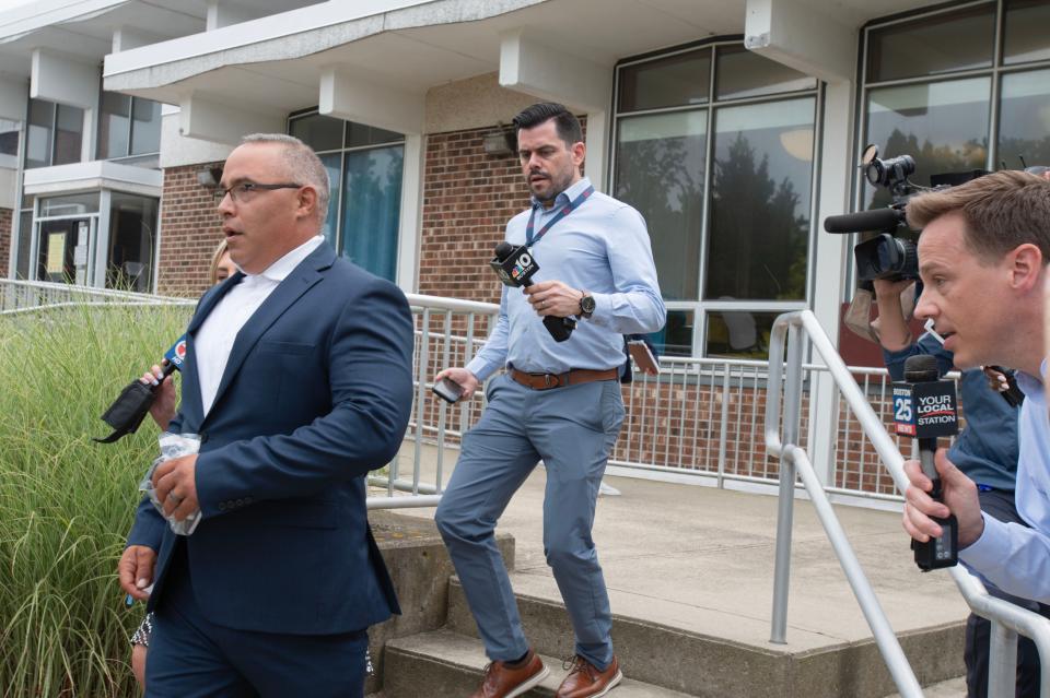 Brewster Police Officer Matthew Marshall is chased by the media for a comment outside Orleans District Court on Thursday after his arraignment on child pornography charges.