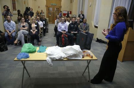 Lecturer in emergency response Amy Hughes (R) speaks to volunteers about specialist personal protective equipment during a National Health Service (NHS) volunteer induction and Ebola information session at the Ministry of Health in London October 15, 2014. REUTERS/Luke MacGregor