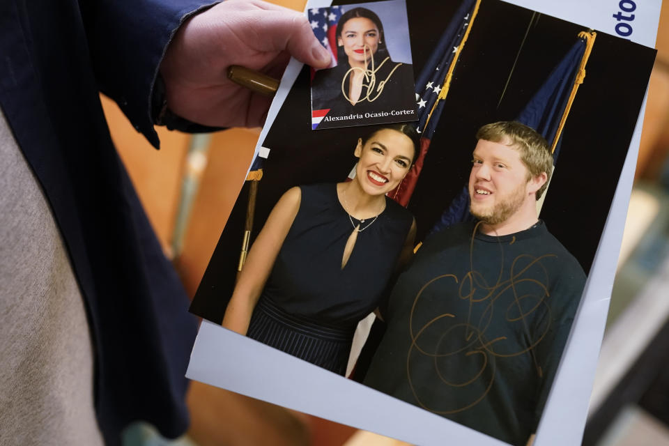 A supporter holds up a signed photo of Rep. Alexandria Ocasio-Cortez, D-N.Y., after she with constituents after her monthly town hall for District NY-14 in the Astoria neighborhood of the borough of Queens in New York, Wednesday, April 20, 2022. As she seeks a third term this year and navigates the implications of being celebrity in her own right, she's determined to avoid any suggestion that she is losing touch with her constituents. (AP Photo/John Minchillo)