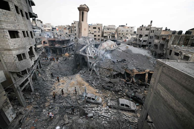 La gente se encuentra entre los escombros de una mezquita destruida durante los ataques aéreos israelíes, en la ciudad de Gaza el 9 de octubre de 2023
