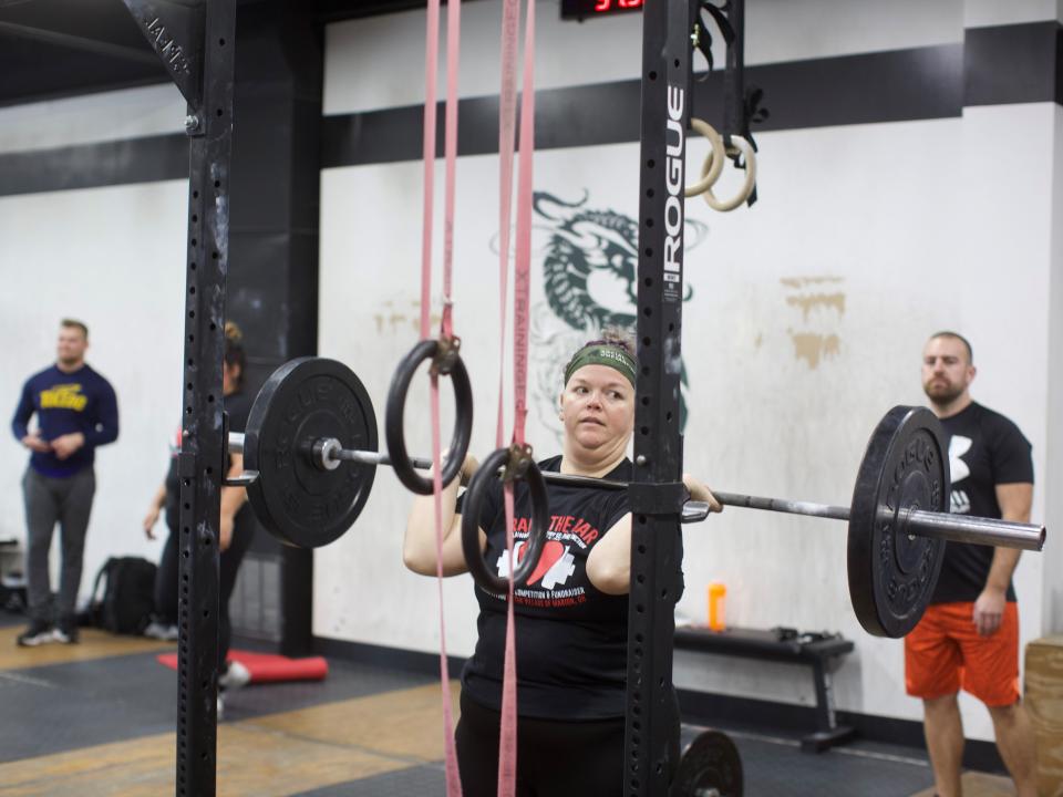 Elizabeth Moore, a coach at Pure Function CrossFit, participates in the "Raise The Bar" fundraiser for Be The Village Marion, an organization she helped launch.