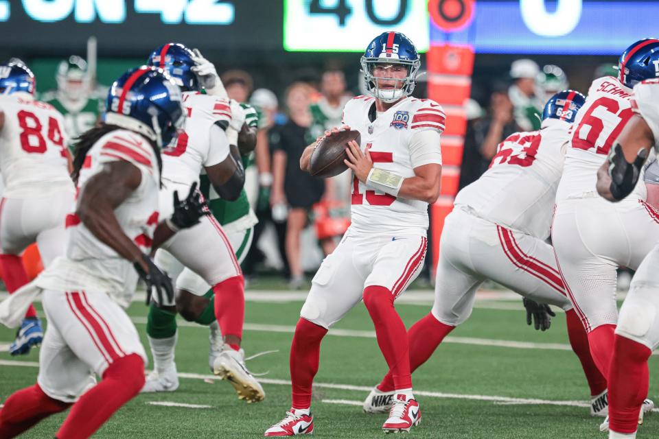 Aug 24, 2024; East Rutherford, New Jersey, USA; New York Giants quarterback Tommy DeVito (15) passes the ball to running back Dante Miller (25) during the first quarter against the New York Jets at MetLife Stadium. Mandatory Credit: Vincent Carchietta-USA TODAY Sports