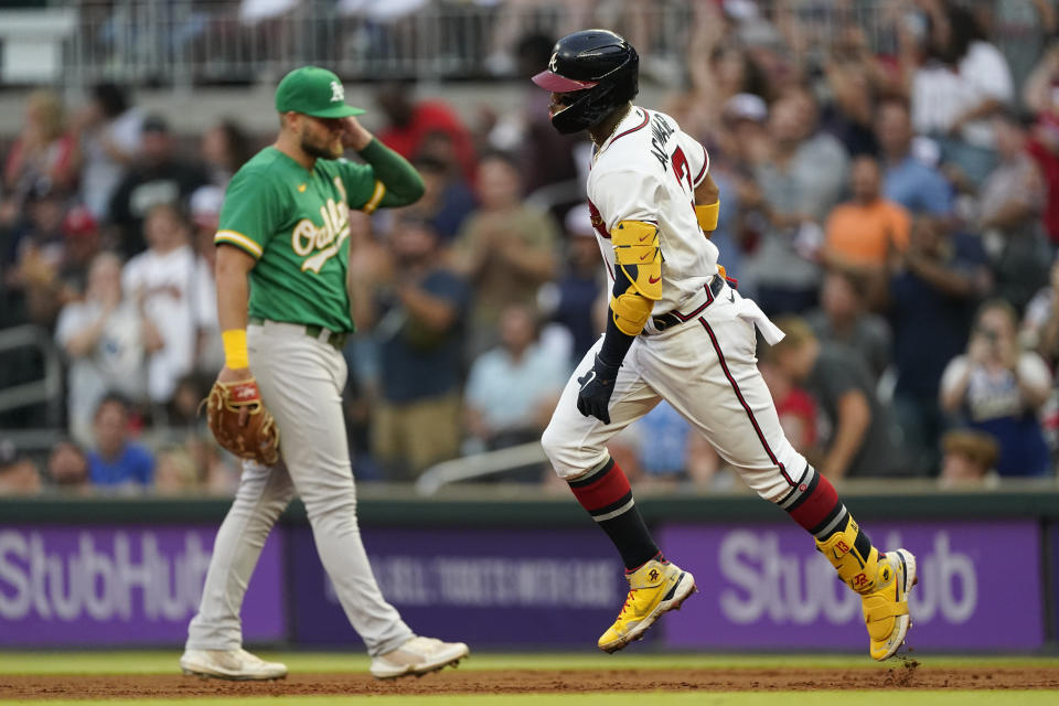 Atlanta Braves' Ronald Acuna Jr. (13) runs past Oakland Athletics first baseman Seth Brown after after hitting a solo home run during the first inning of a baseball game Tuesday, June 7, 2022, in Atlanta. (AP Photo/John Bazemore)