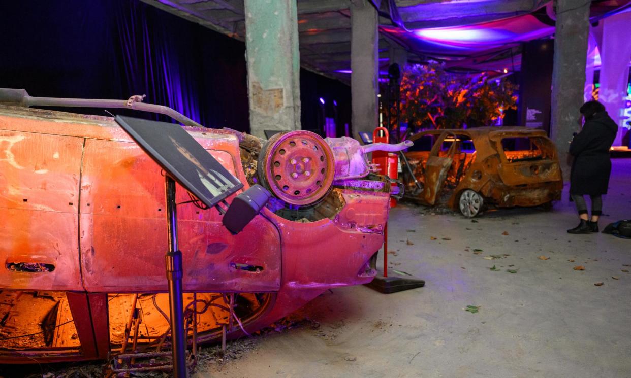 <span>Two burnt-out cars from the festival site on display at the exhibit.</span><span>Photograph: Alexi Rosenfeld/Getty Images</span>