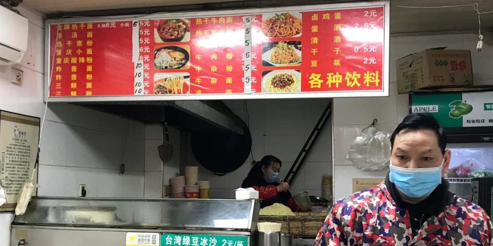 Stores owners of a store selling a local favorite "reganmian," or "hot dry noodles," prepare takeaway orders in Wuhan in central China's Hubei province, Tuesday, March 31, 2020. The reappearance of Wuhan's favorite noodles is a tasty sign that life is slowly returning to normal in the Chinese city at the epicenter of the global coronavirus outbreak. The steady stream of customers buying bags of noodles smothered in peanut sauce testifies to a powerful desire to enjoy the familiar again after months of strict lockdown. (AP Photo/Olivia Zhang)