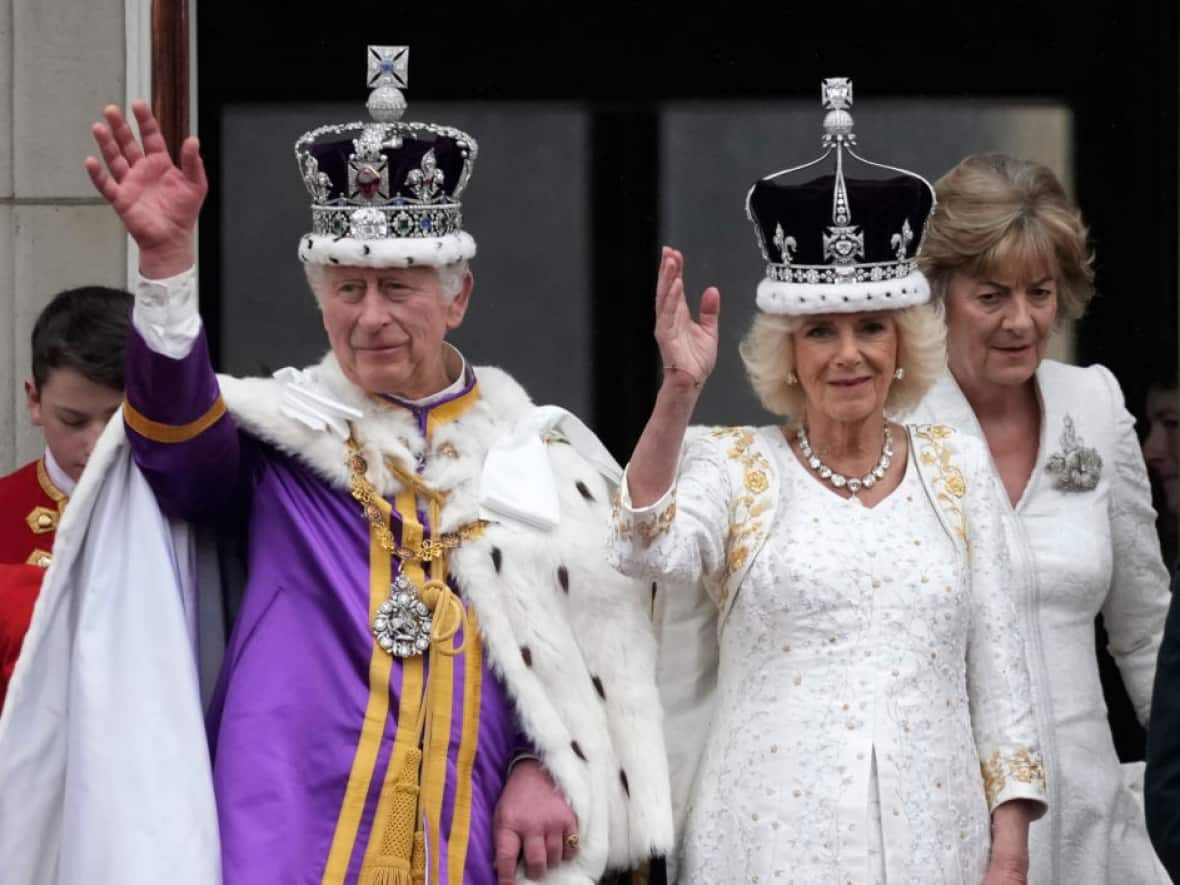King Charles III and Queen Camilla can be seen on the Buckingham Palace balcony ahead of the flypast during the Coronation of King Charles III and Queen Camilla on May 6, 2023 in London, England. (Christopher Furlong/Getty Images - image credit)