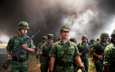 Mexican Navy and anti-narcotics personnel burn packs with part of a seizure of 5 tons of cocaine and marijuana in Acapulco - Credit: FRANCISCO ROBLES/ AFP