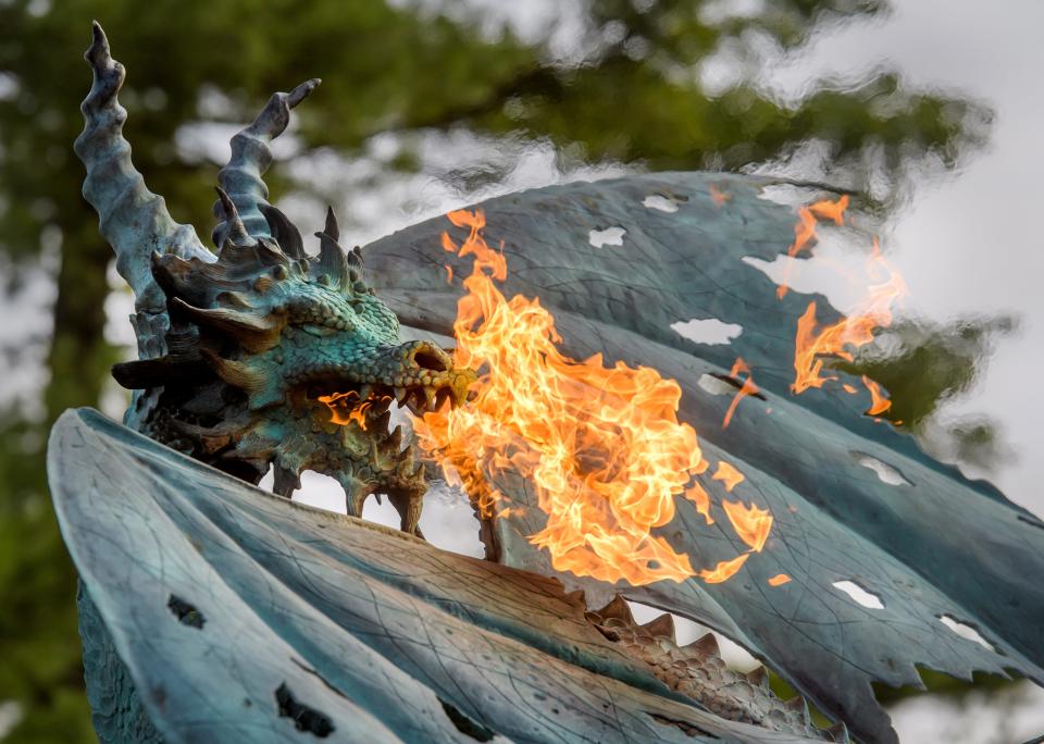 A dragon perched at the driveway entrance to the castle on Grandview Drive spews flames from its mouth Thursday, Oct. 27, 2022 in Peoria Heights. The Soderstrom family is holding its annual Halloween spectacle once again, complete with fire-breathing dragons, "Ghostbusters" themed inflatables and an elaborate sound and light show.