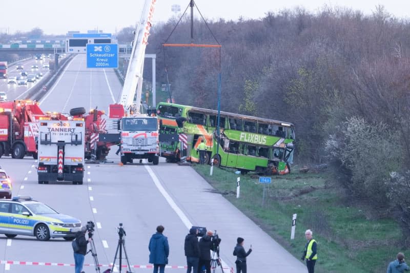 A crane recovers the coach involved in an accident at the A9. At least five people died and several were injured in an accident involving a coach on the A9 near Leipzig. Sebastian Willnow/dpa