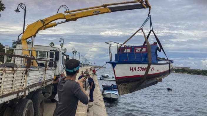 Workers remove a boat from the water in the bay of Havana, Cuba on Monday. Hurricane Ian was growing stronger as it approached the western tip of Cuba on a track to hit the west coast of Florida as a major hurricane as early as Wednesday. (Photo: Milexsy Duran/AP)