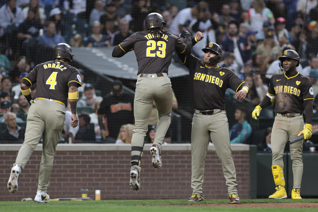 San Diego Padres' Fernando Tatis Jr. (23) celebrates with, from left, designated hitter Luis Arraez (4) Donovan Solano and Jurickson Profar after hitting a three-run home run the third inning of a baseball game against the Seattle Mariners, Tuesday, Sept. 10, 2024, in Seattle. (AP Photo/Jason Redmond)