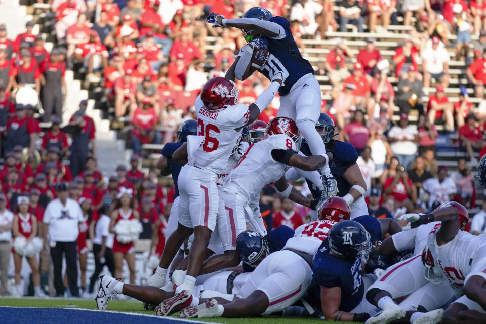 Rice running back Daelen Alexander, top, is stopped at the goal line by Houston linebackers Jalen Garner, left, and Houston linebacker Malik Robinson (8) during the first half of an NCAA college football game, Saturday, Sept. 9, 2023, in Houston. (AP Photo/Eric Christian Smith)
