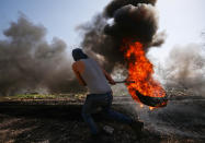 <p>A Palestinian protestor carries a burning car tire during clashes with Israeli security forces in the village of Kfar Qaddum, near Nablus, in the occupied West Bank, Feb. 24, 2017. (Photo: Mohamad Torokman/Reuters) </p>