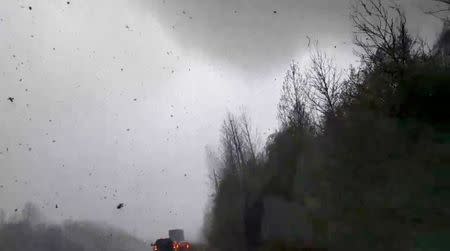 Cars are seen on a road during a tornado in Mountainburg, Arkansas, U.S., April 13, 2018 in this picture grab obtained from social media video. JOSHUA COLEMAN/via REUTERS