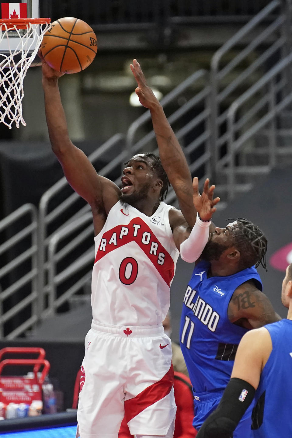 Toronto Raptors guard Terence Davis (0) scores after getting around Orlando Magic forward James Ennis III (11) during the second half of an NBA basketball game Sunday, Jan. 31, 2021, in Tampa, Fla. (AP Photo/Chris O'Meara)