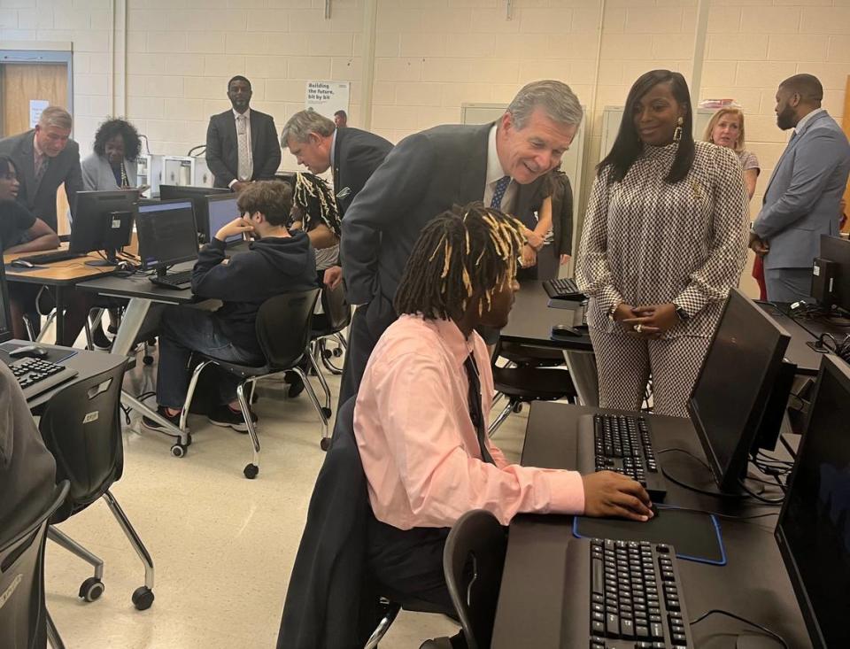 Gov. Roy Cooper asks a Durham Public Schools student about coding on a visit to a computer science class taught by Laquanta Ford, right, at Southern School of Energy and Sustainability on April 13, 2023.