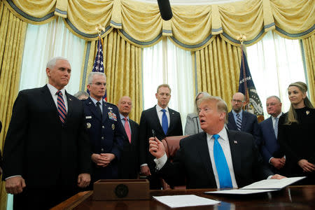 U.S. President Donald Trump looks to Vice President Mike Pence as he participates in a signing ceremony of "Space Policy Directive 4," to establish a Space Force as the sixth branch of the Armed Forces, in the Oval Office at the White House in Washington, U.S., February 19, 2019. REUTERS/Jim Young