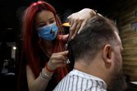Barber Kinga Rutkowska, 22, cuts hair at a barbershop in Warsaw