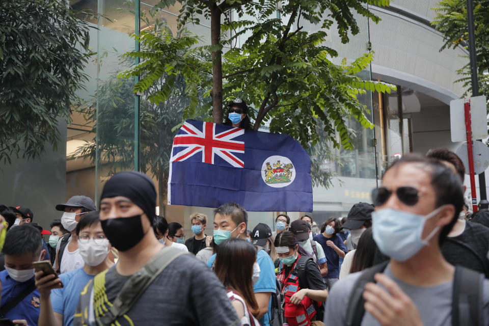 A man displays the Hong Kong colonial flag on the anniversary of Hong Kong's handover to China from Britain in Hong Kong, Wednesday, July. 1, 2020. Hong Kong marked the 23rd anniversary of its handover to China in 1997, and just one day after China enacted a national security law that cracks down on protests in the territory. (AP Photo/Kin Cheung)